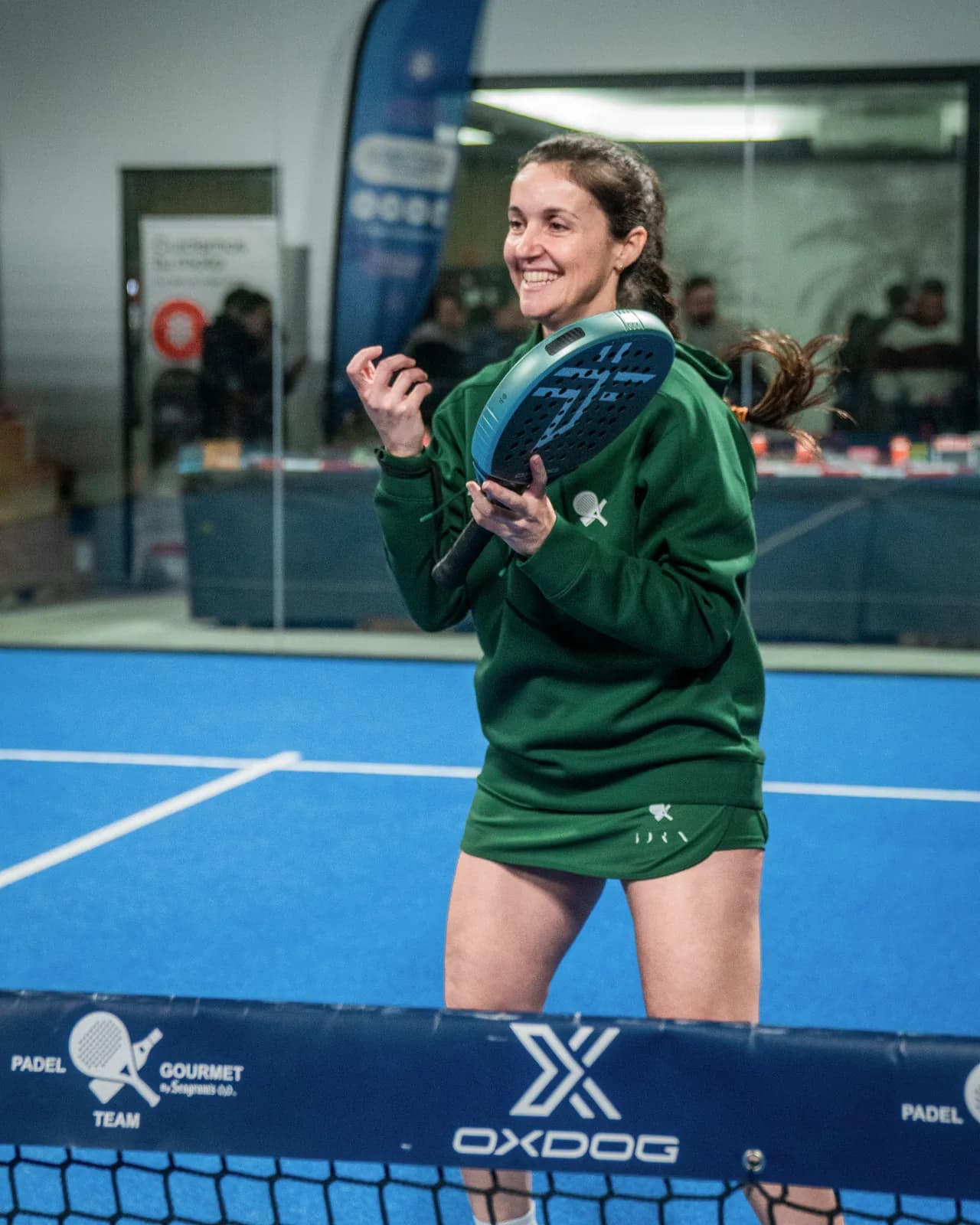 jugadora con la sudadera verde de PTG y pala en pista